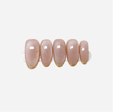 Set of pink nail extensions with gold accents on a light gray background